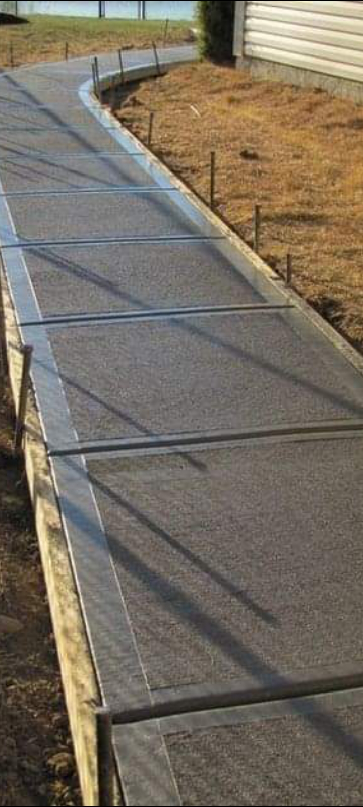 Long broom-finished concrete sidewalk along a home